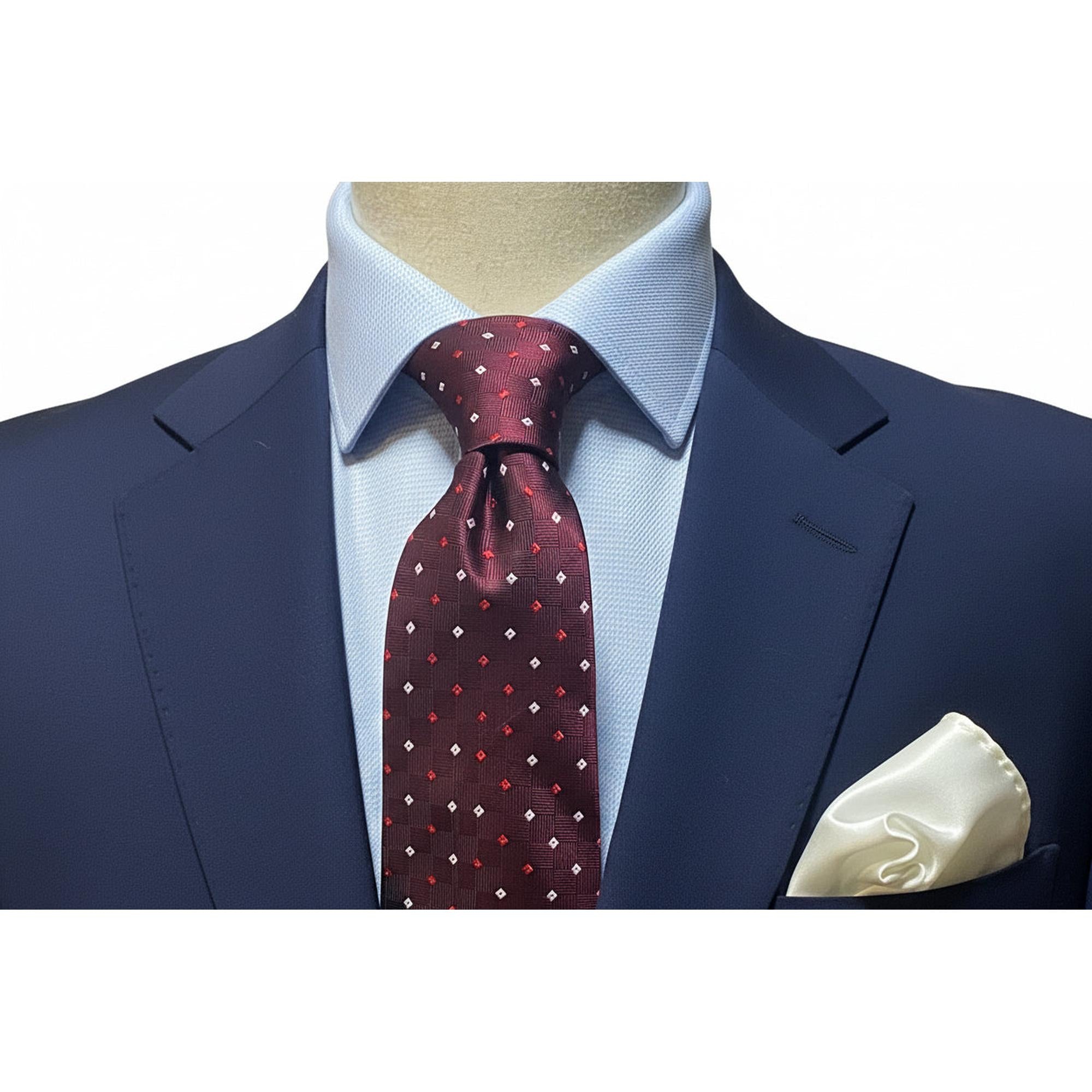 Burgundy small square tie White and Red worn with a navy suit and white pocket square, showcasing elegance and style.