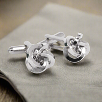 Silver Silk Knot Cufflink displayed on a soft fabric background, showcasing its elegant knot design and shiny silver finish.