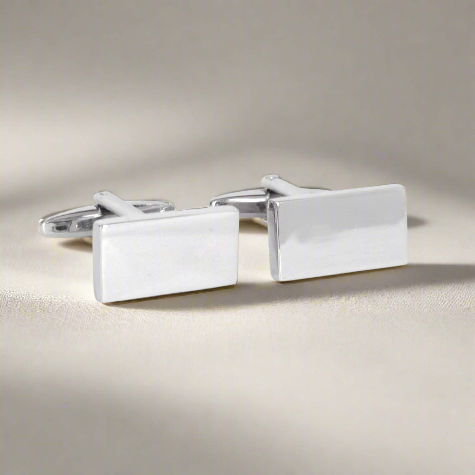 Pair of silver rectangular cufflinks on a light background