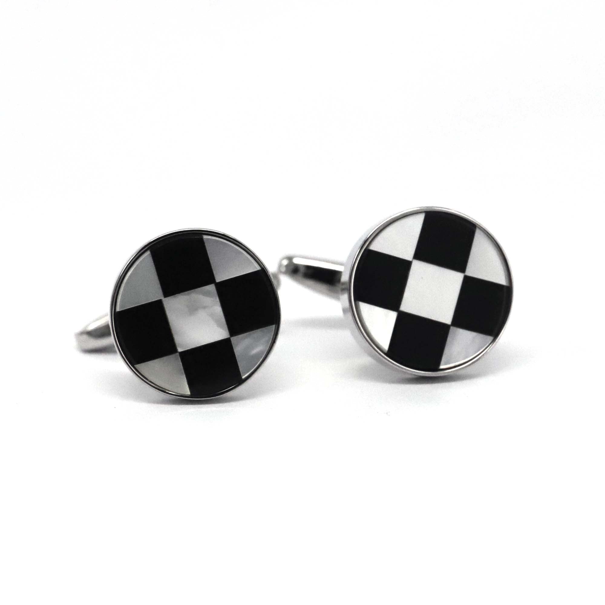 A pair of round silver white cufflinks with a black and white chess design, rhodium plated copper alloy, displayed against a white background.
