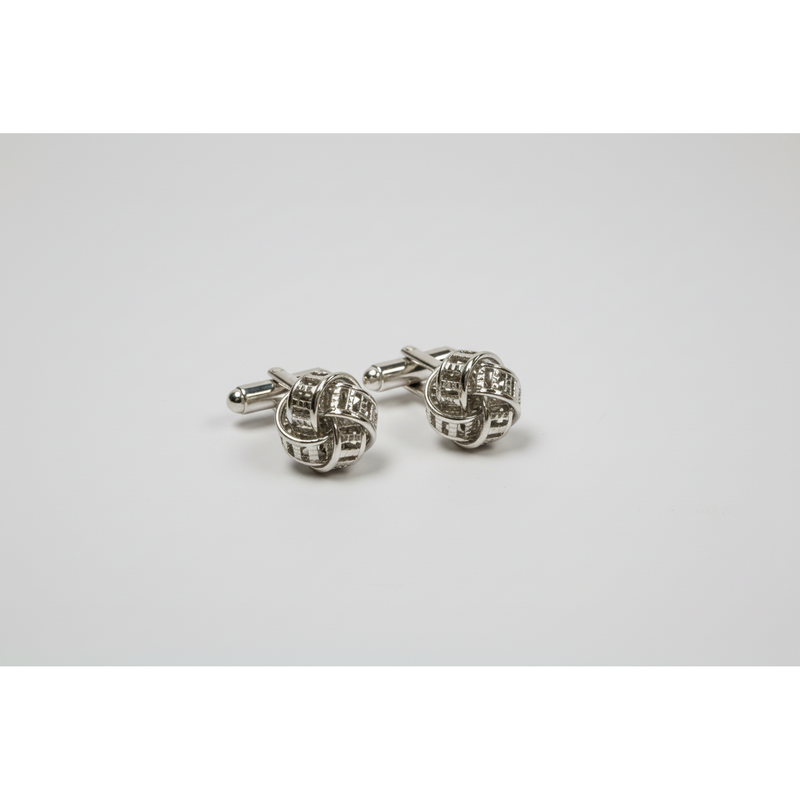 Silver knot cufflinks on a light gray background
