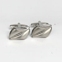 Pair of silver cufflinks on a white background