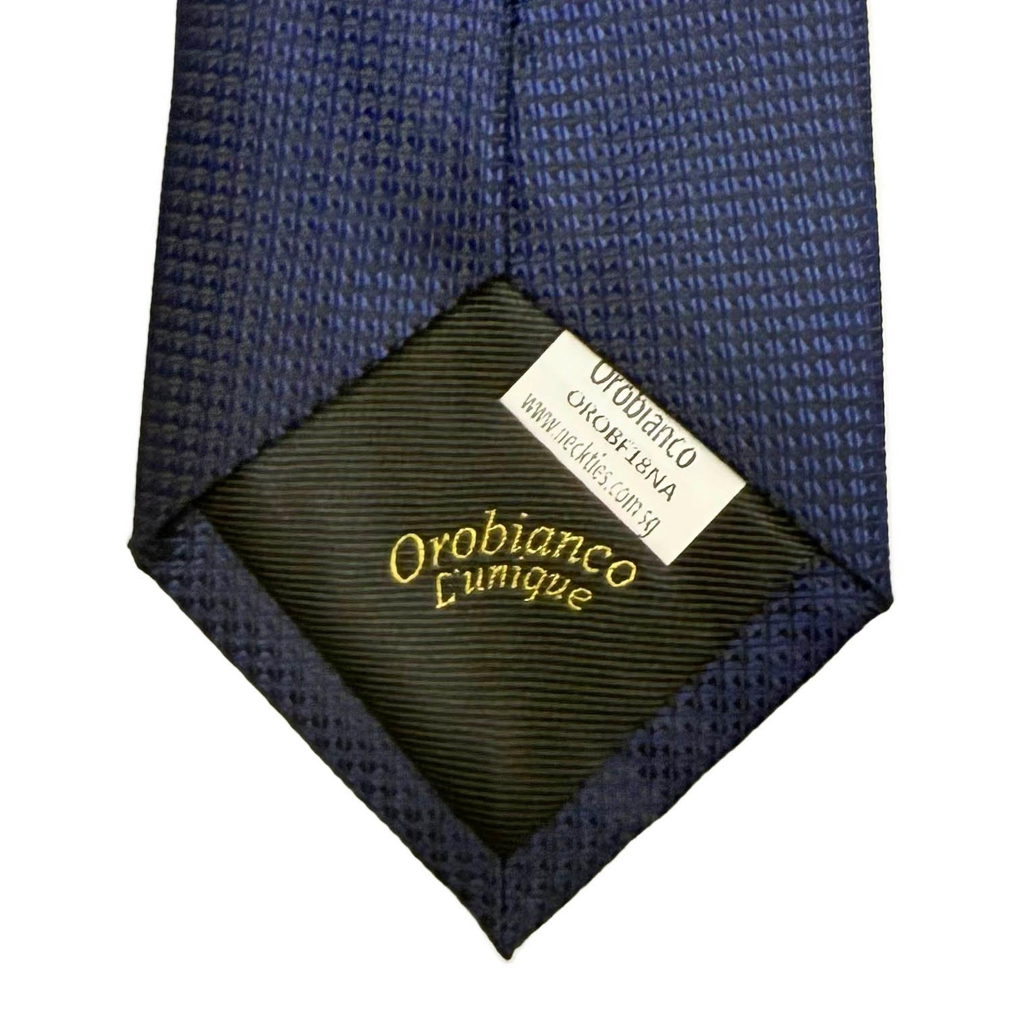 Navy blue tie with a visible brand label on a white background