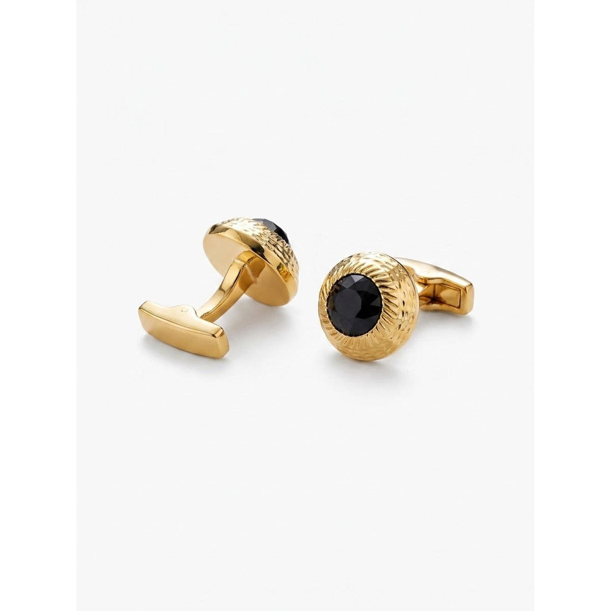 A pair of gold cufflinks with textured circular faces and central black oval inlays, photographed on a clean white background.