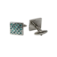 Silver cufflinks with a geometric design on a gray background