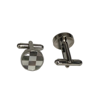 A pair of silver-toned metal cufflinks on a Plan background. One cufflink is shown from the front, featuring a round face with a black and white checkered pattern, and the other is shown from the side/back, displaying its polished silver-toned metal construction.