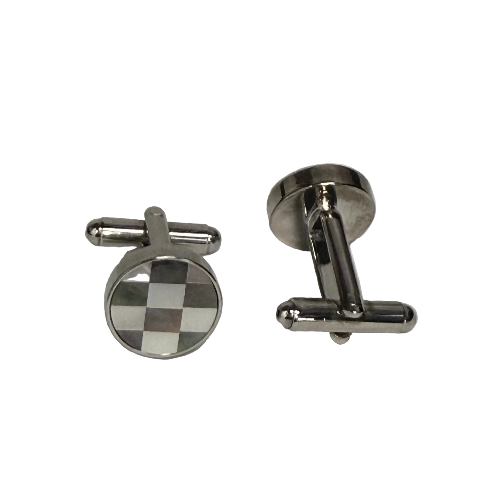 A pair of silver-toned metal cufflinks on a Plan background. One cufflink is shown from the front, featuring a round face with a black and white checkered pattern, and the other is shown from the side/back, displaying its polished silver-toned metal construction.