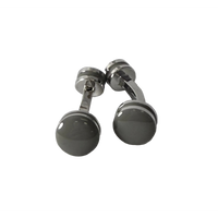 A pair of silver-toned cufflinks with round, polished dark gray to black faceted front discs, photographed on a light gray textured surface.