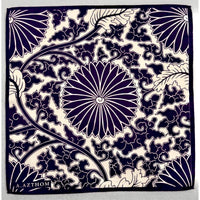 A square pocket squre  featuring a navy blue and cream floral pattern with a central chrysanthemum and swirling vine motifs. The brand name 'Azthom'