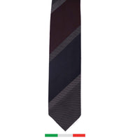A custom made silk striped tie in grey and maroon colors with a visible Italian flag-like embroidery detail.