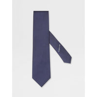 Navy blue tie with a brand logo on a light gray background