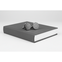 Black horizontal stripe cufflinks on a grey book, showcasing a modern design for formal attire.