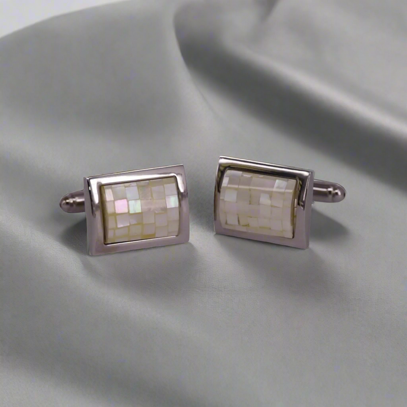 Pair of rectangular cufflinks with mosaic design on a gray fabric background