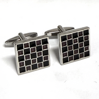 Pair of square cufflinks with black and silver checkered pattern on a white background
